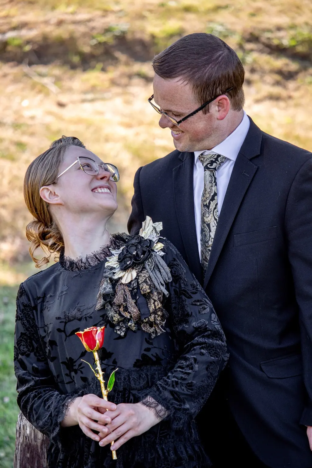 Alyssa holding a rose while she and Caleb smile at one another